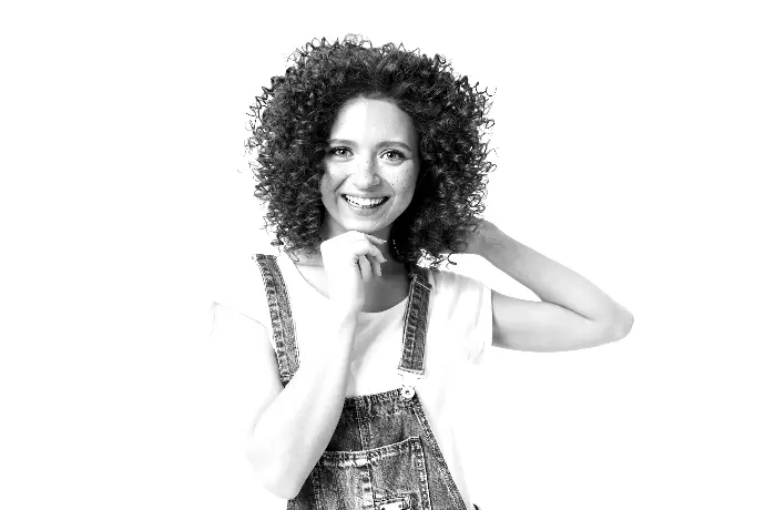 a woman with red curly hair wearing overalls