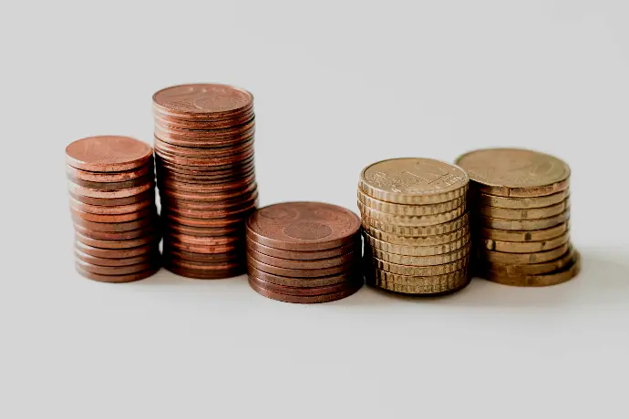 stacked round gold-colored coins on white surface